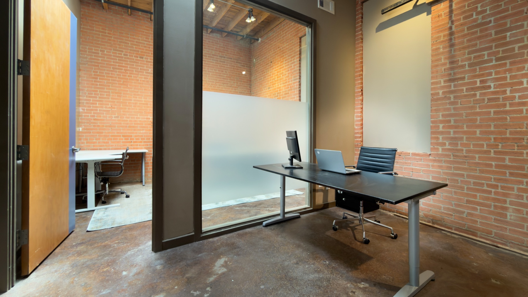 Current GeniusDen glass office and reception desk area